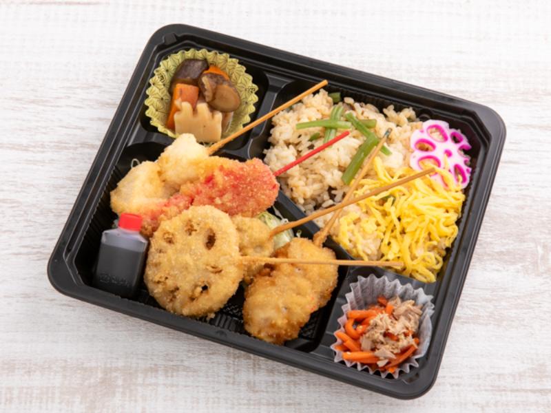 季節の混ぜご飯と串カツ弁当（蓮根、豚バラ、いか、紅生姜、じゃがいも）
