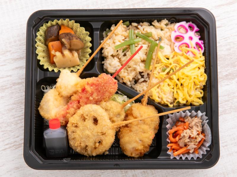 季節の混ぜご飯と串カツ弁当（蓮根、豚バラ、いか、紅生姜、じゃがいも）